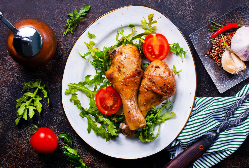 Fried chicken drumsticks on a plate with arugula