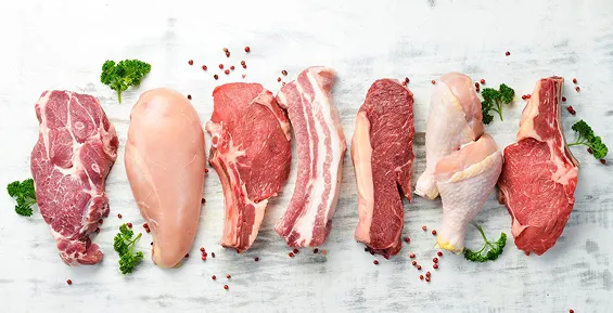 Assorted raw meat cuts including beef, pork and chicken on white surface